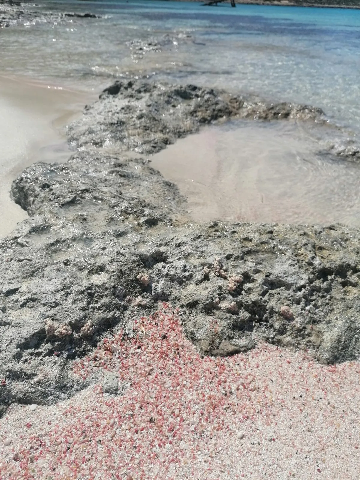 The pink-tinted sand and shallow lagoon at Elafonissi beach in Crete