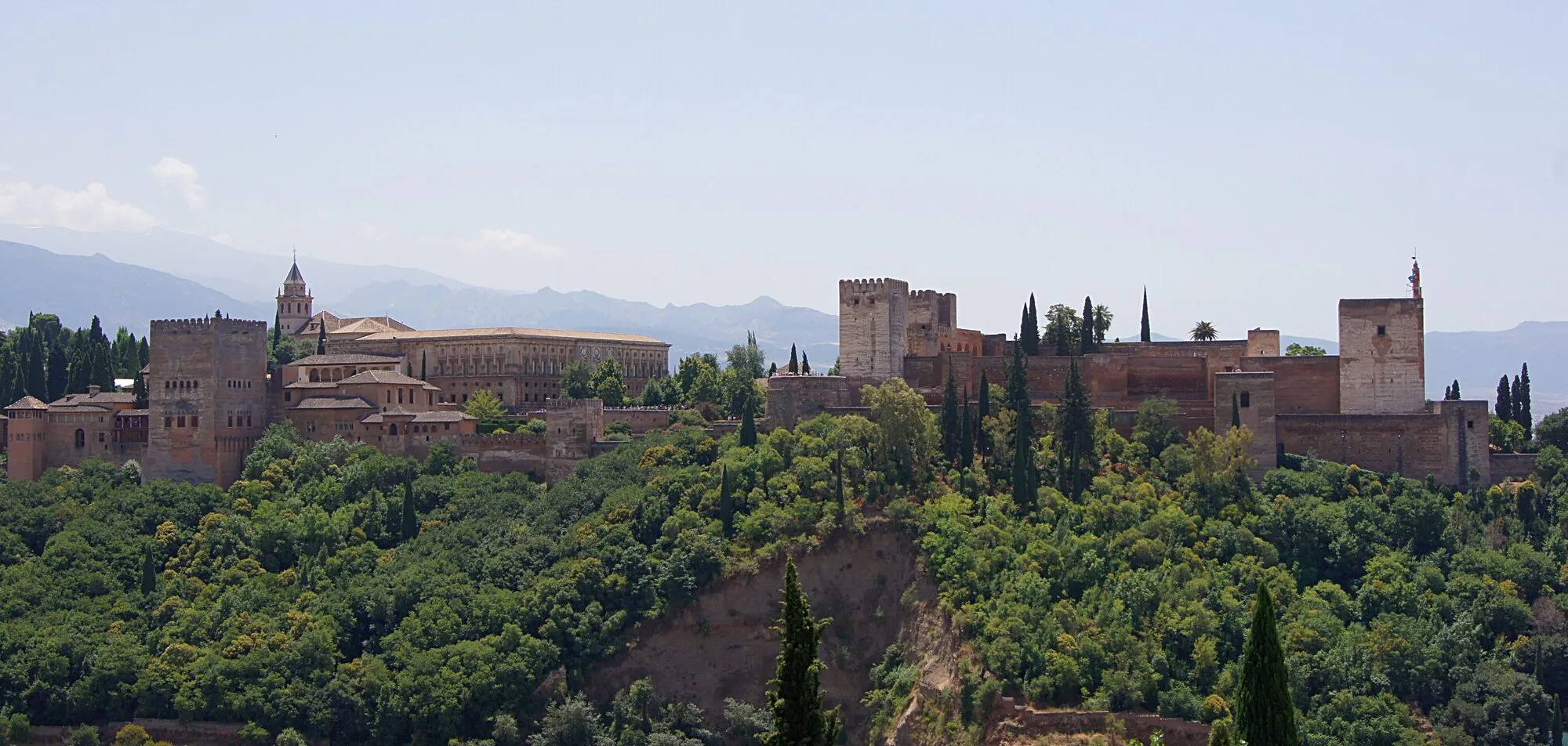 The Alhambra palace complex on its hill above Granada, Spain, seen from the Mirador de San Nicolas, with the Sierra Nevada behind