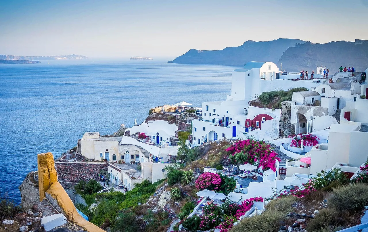 The white-washed houses and blue domes of Oia in Santorini, Greece, above the caldera