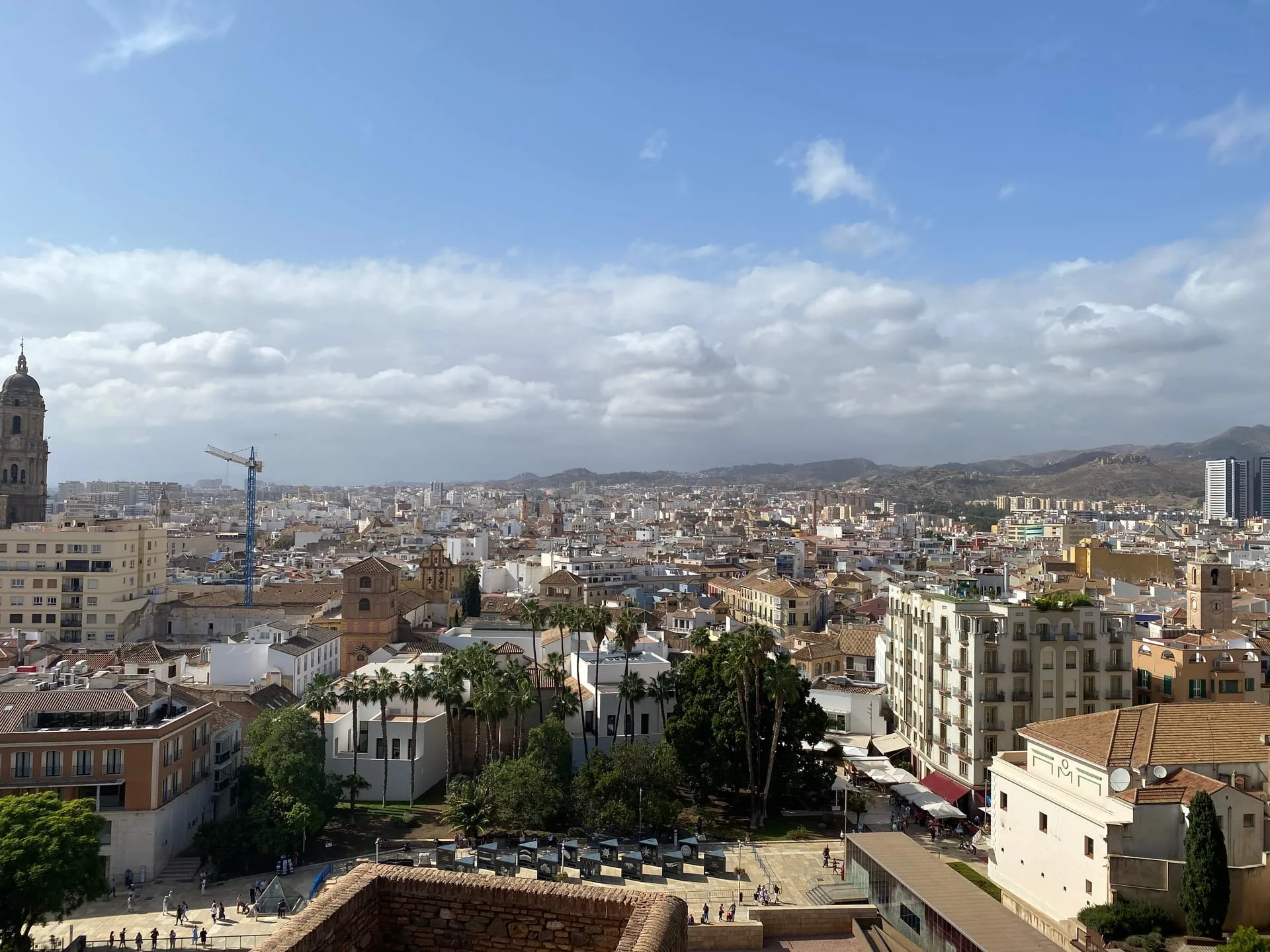 The city of Málaga seen from the Alcazaba, with the cathedral tower and the mountains behind