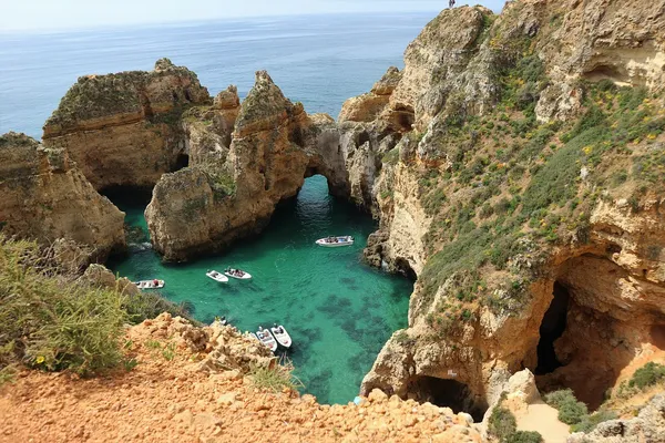 The golden cliffs and coves of the Algarve coast at sunset, Portugal