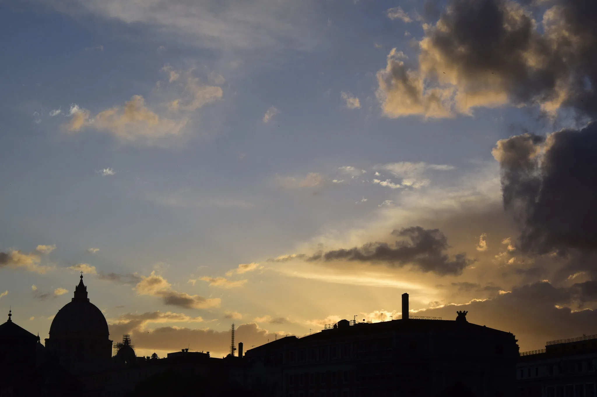 Rome skyline at sunset with the dome of St Peter's Basilica above the city rooftops