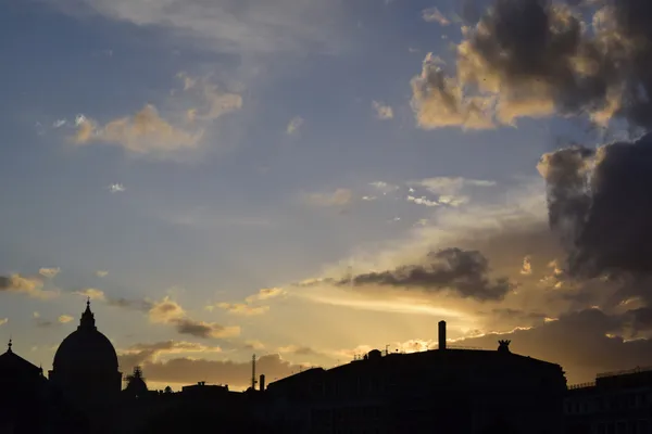 Rome skyline at sunset with the dome of St Peter's Basilica above the city rooftops