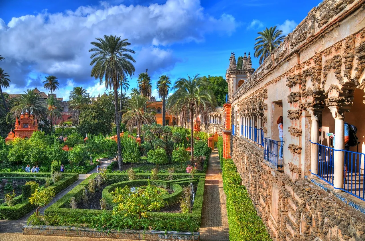 The Alcazar gardens in Seville, Spain, with orange trees and Moorish arches