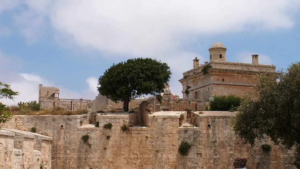 The stone walls and watchtower of Mdina, Malta, under a blue sky