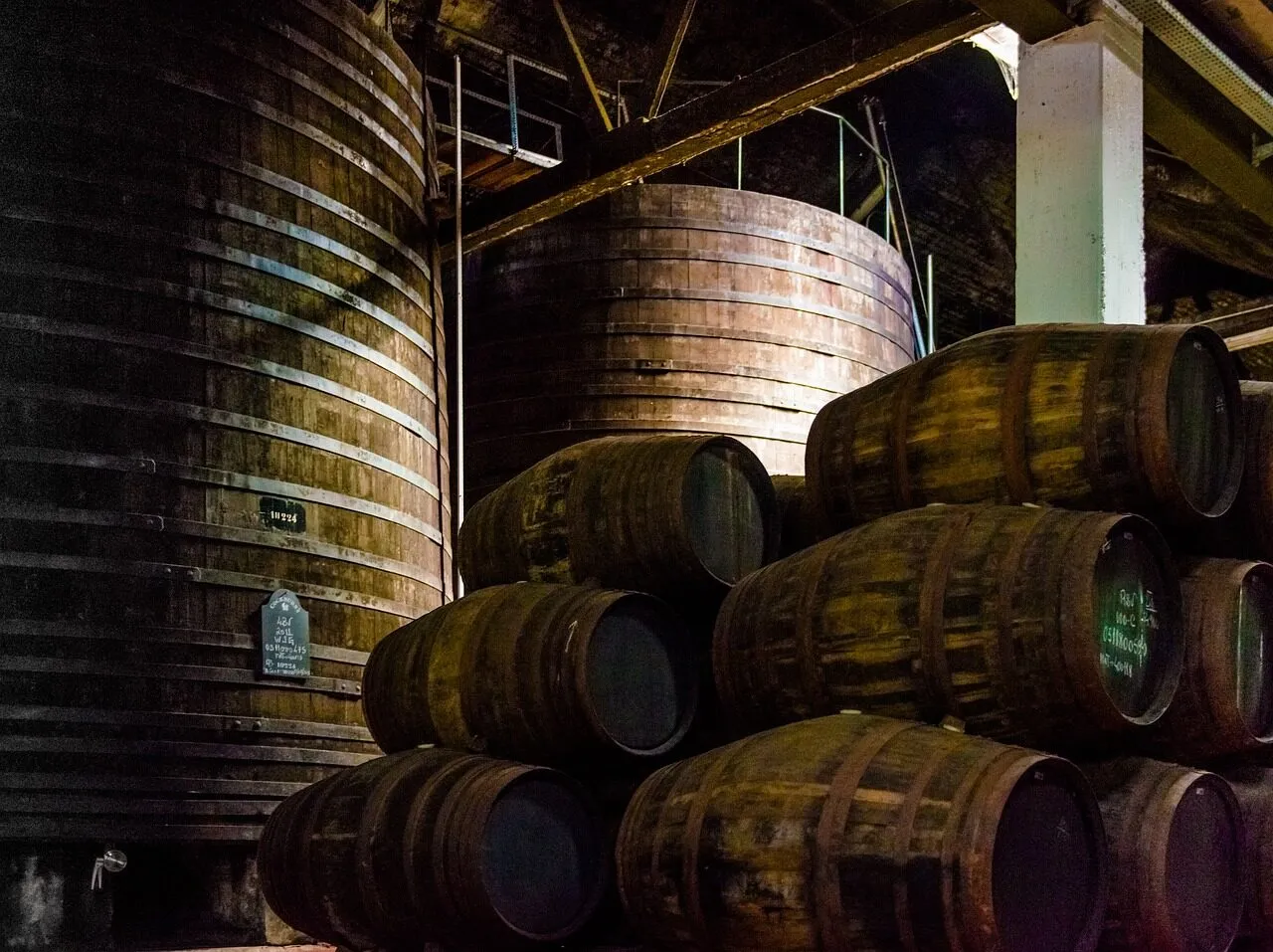 Rows of wooden port wine vats and barrels ageing in a cellar in Vila Nova de Gaia