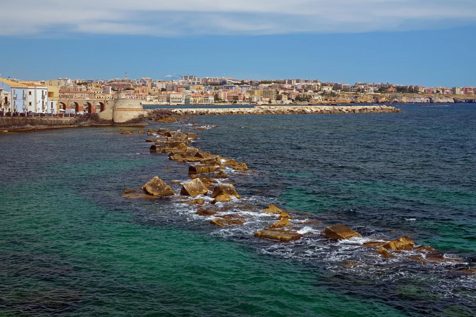 The sea front of Ortigia in Syracuse with Mount Etna on the horizon, Sicily